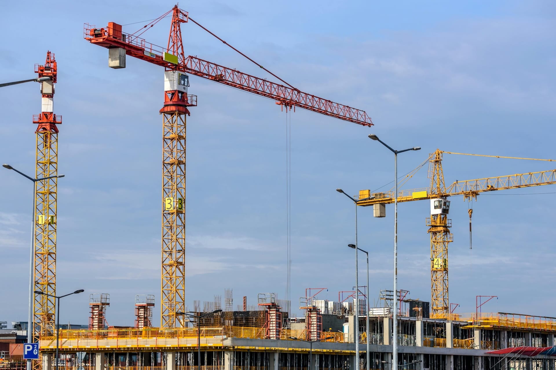 Photo of three cranes on a construction site